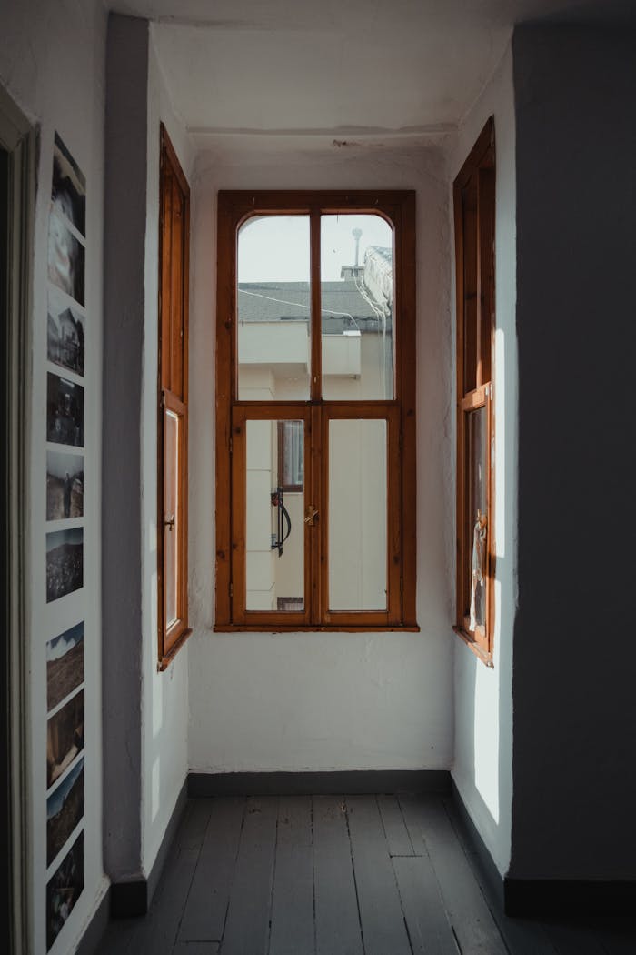 Bright indoor hallway with wooden-paneled windows filtering sunlight, creating a cozy atmosphere.